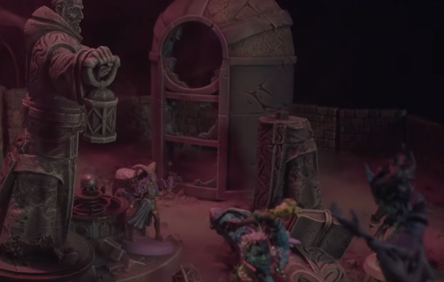 A battlemap focusing on an animated statue looming over Imogen, with Ashton and Laudna surrounded by the form of Delilah in the foreground. The statue stands on a circular platform with an orb on it. Behind it is a tall hollow structure with broken windows.