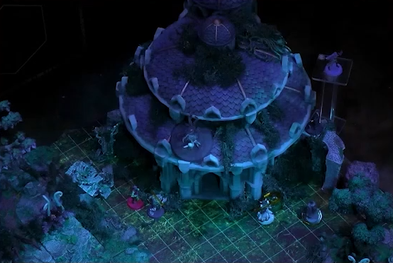 A battlemap focused on a building with a pale purple shingled roof. Ashton, Orym, Braius, and wolven Chetney stand by the doorway while Imogen flies behind the building and the Nightmare King stands on the roof above the entrance.