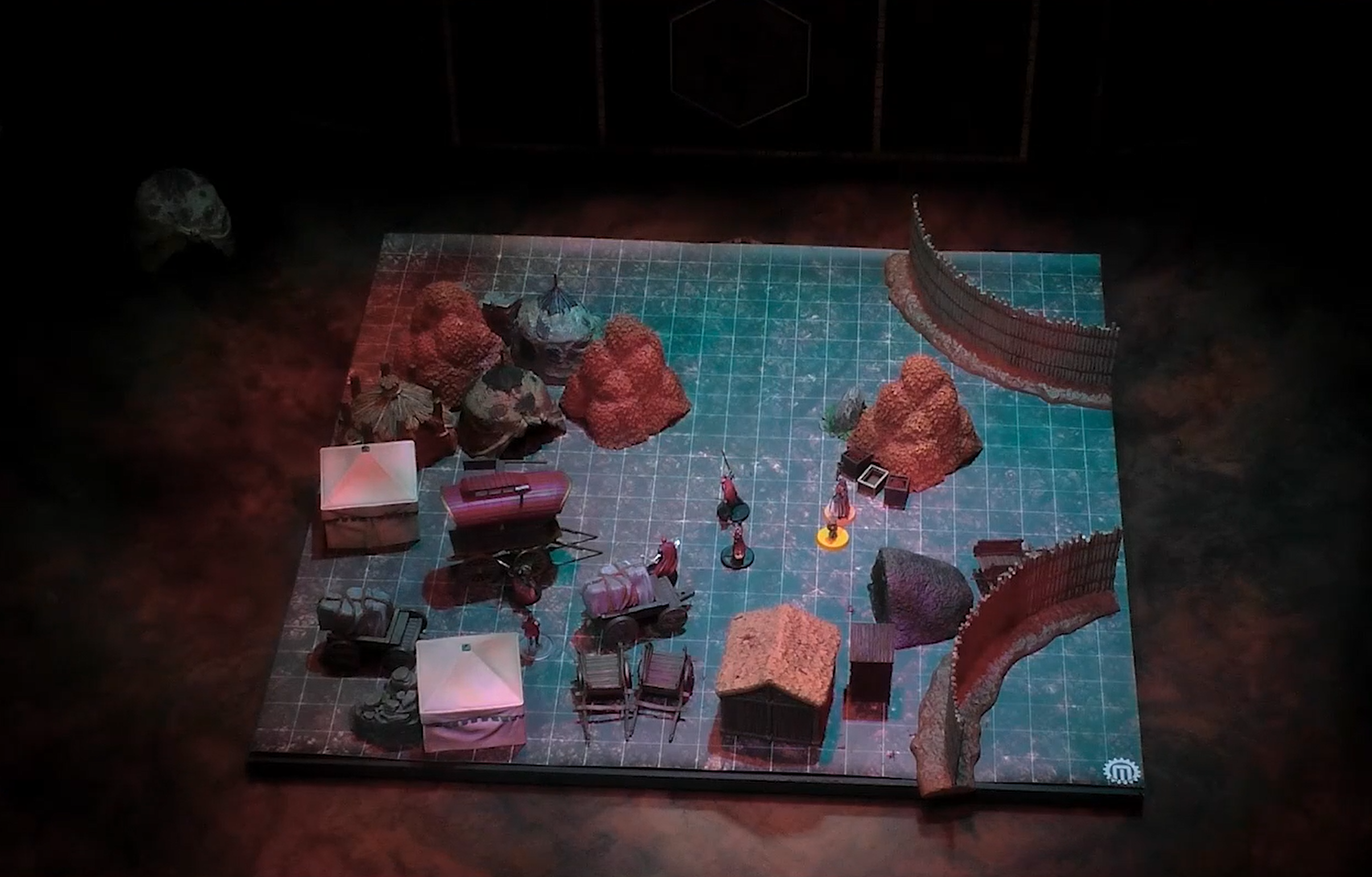 A battlemap with two rounded fences on one side, a number of tents, wagons, and huts on the other side. In the center are Otohan and some Vanguard members, with Fearne and FCG nearby.