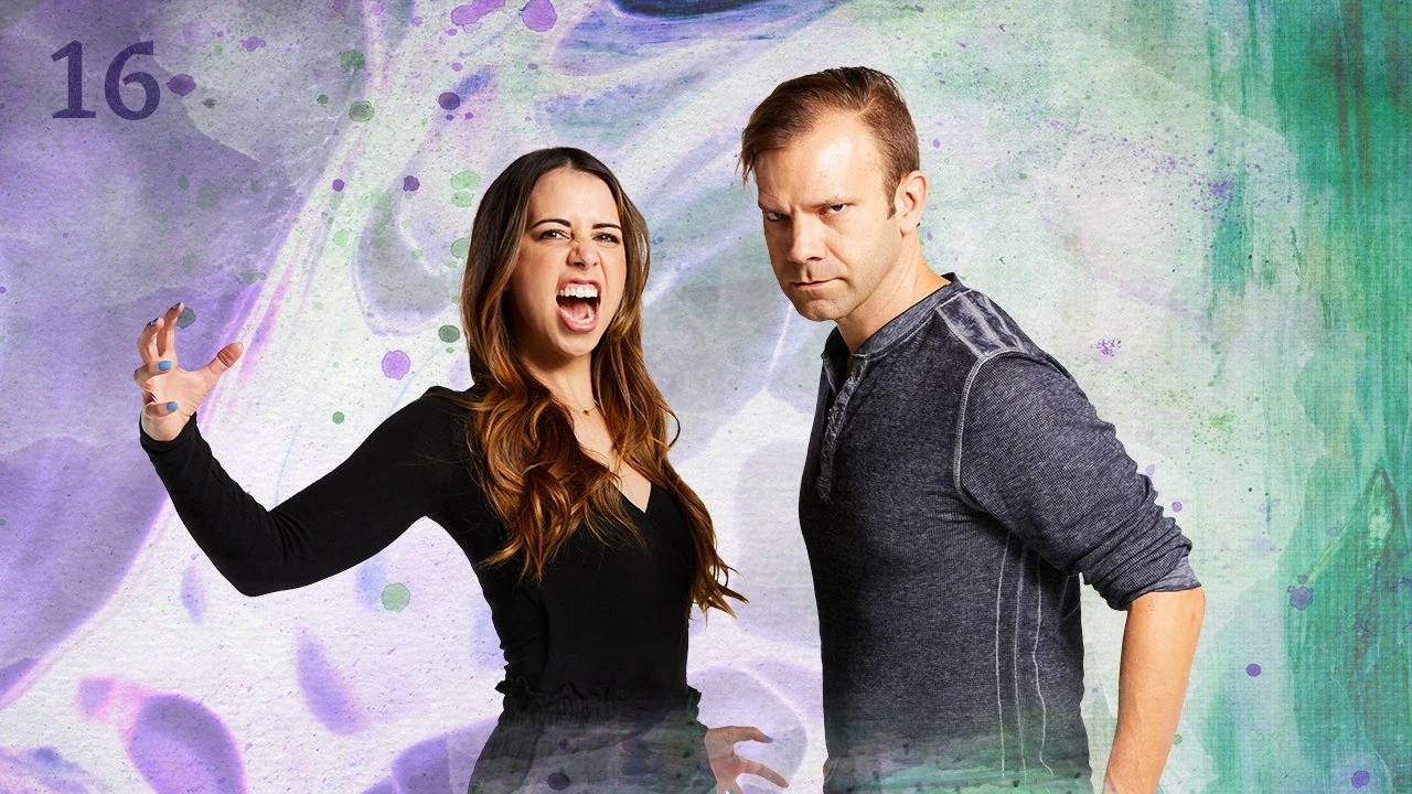 Thumbnail for episode 16. Laura and Liam pase in battle stances, staring intensely at the camera. Laura’s mouth is open in a yell are her arms are spread wide. Liam stands sideways, ready to spring. They are dressed in black and gray and stand against a colorful backdrop with lava-lamp-like swirls of purples and greens over white.